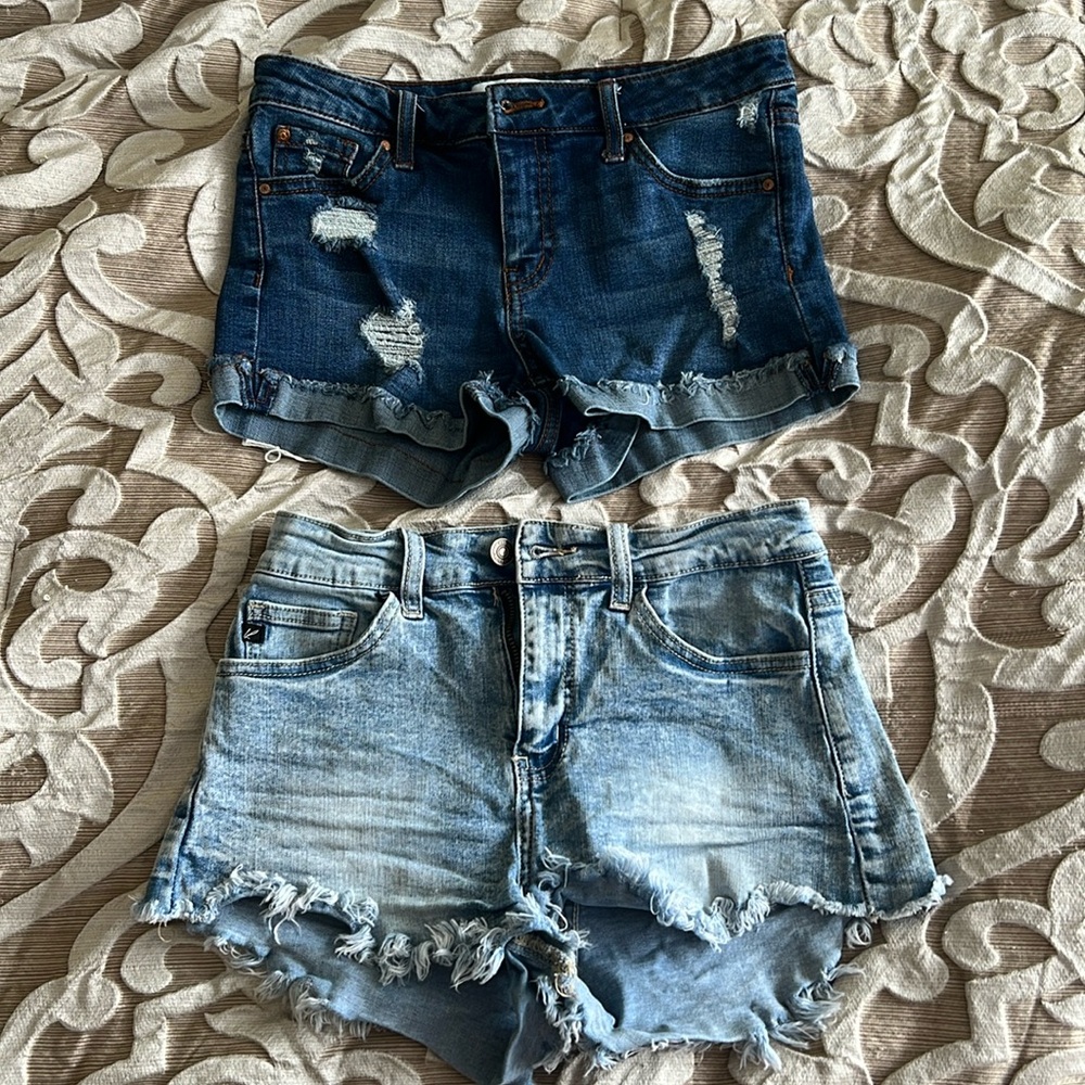 Two pairs of jeans shorts, one deeper blue, one light blue.